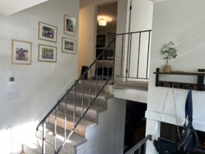 Old metal handrailing on carpeted indoor stairs.